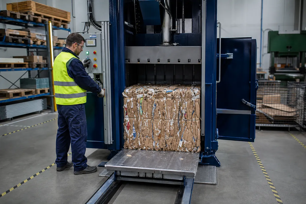 Vertikalni balirni stroj med stiskanjem kartona v čistem industrijskem prostoru